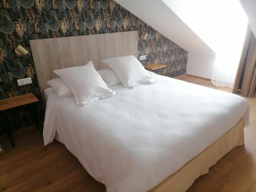 安锡堪塔帕酒店的一张配有白色床单和枕头的大床