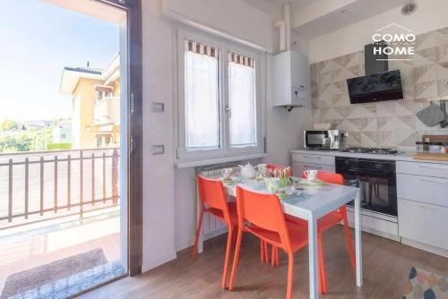 科莫Como Holiday Home Appartamento ideale per famiglie的一个带桌椅的厨房和一个阳台