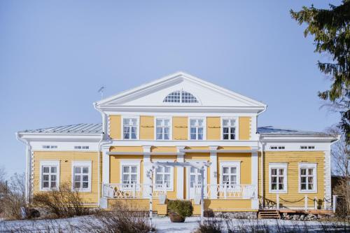 SulkavaTiittalan Kartano的白色屋顶的大型黄色房屋