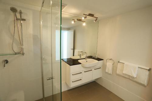 汤斯维尔帕丁顿Q度假村公寓的一间带水槽和玻璃淋浴的浴室