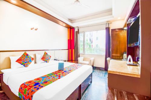 新德里FabHotel Marble Arch的一间酒店客房,配有一张床和一台电视
