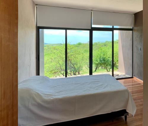 Villa San NicolásCasa de campo的一间卧室设有一张床和一个大窗户