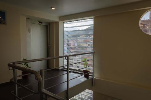库斯科Group House Apart Hotel的客房设有带窗户和植物的楼梯。