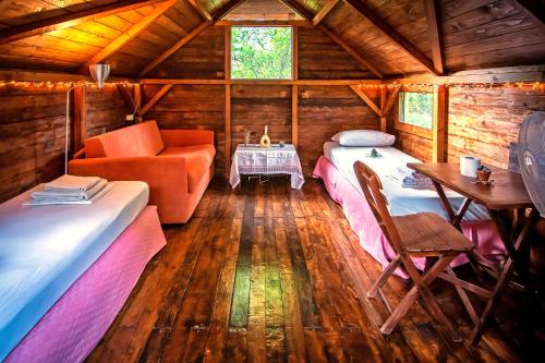 塞奥洛戈斯Drolma Ling Nature Cabins的小屋内带两张床和一张沙发的房间