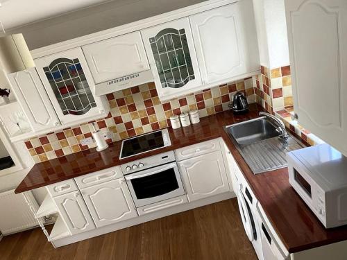 阿尔弗斯顿Burlington Cottage - Ulverston, Lake District.的厨房配有白色橱柜和水槽