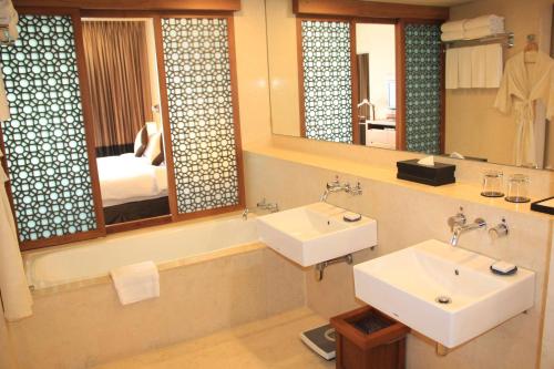 达卡Radisson Blu Dhaka Water Garden的一间带两个盥洗盆和大镜子的浴室