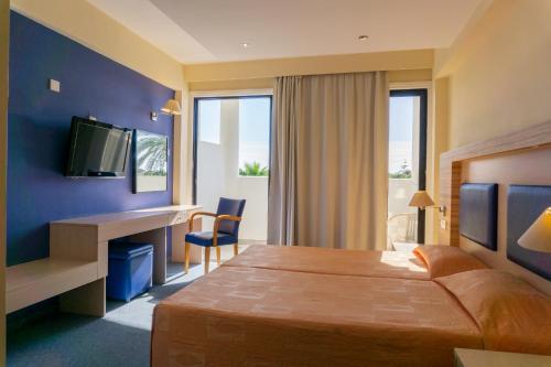 拉纳卡玛丽安第酒店的酒店客房配有一张床、一张书桌和一台电视。