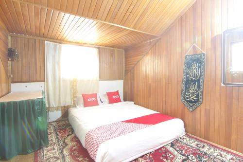 TabingNew Bunga Sonsang Homestay Syariah的一间带一张大床的卧室,位于带木墙的房间