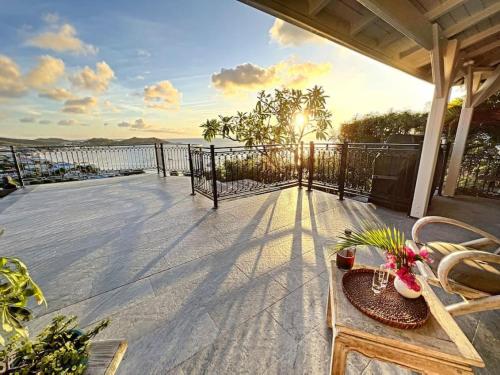 格兰德凯斯Frangipani Room in shared Villa Diamant, swimming pool, sea view的阳台的天井配有桌椅