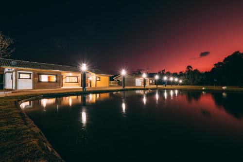 波苏斯-迪卡尔达斯Pousada Trem Chic的夜间游泳池,灯光照亮