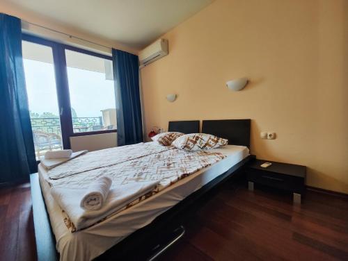 金沙Europroperties Zlatna Kotva Apartments的一间卧室设有一张床和一个大窗户