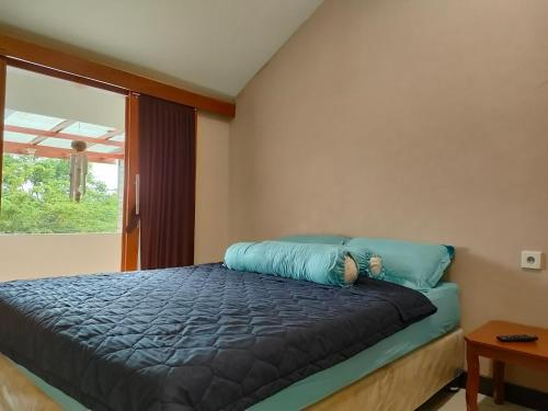 特勒贡villa Eco green的一间卧室配有一张带蓝色枕头的床