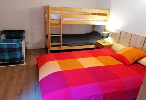 米茹Le grand duc的一间卧室配有一张色彩缤纷的床和双层床。