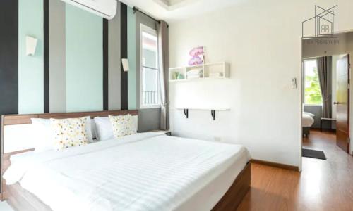 清迈Villa Rajapruek Entire 3 villa with pool near Airport and city center的卧室配有一张白色大床