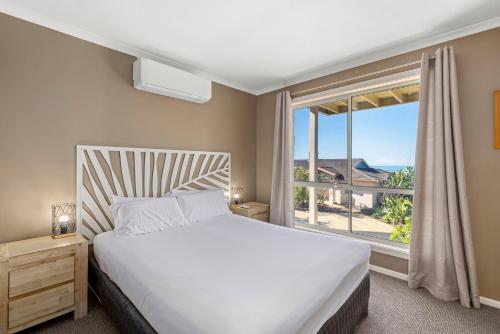 科夫斯港水月海滩度假酒店的一间卧室设有一张床和一个大窗户