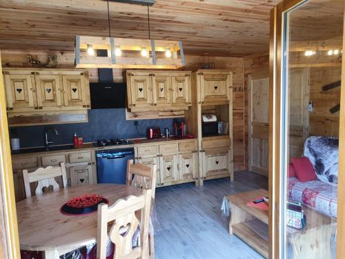 拉内默藏Chez LAVALOU Gîte 4* chaleureux en bois的小屋内的厨房配有木制橱柜和桌子