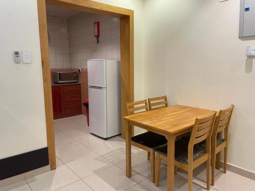 艾卜哈أبها ريجنسي的厨房配有桌子和白色冰箱。