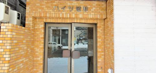 札幌札幌市中心部大通公園まで徒歩十分観光移動に便利なロケーションh203的砖砌的建筑,有玻璃门,上面有标志