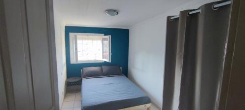 吕内尔Appartement 45 m² proche du centre ville的小房间设有一张带窗户的床