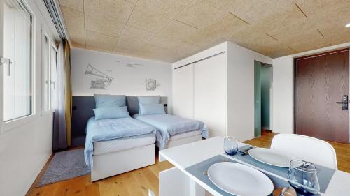 伯尔尼Evi's Home Hotel & Apartments的一间设有两张床和一张桌子的房间