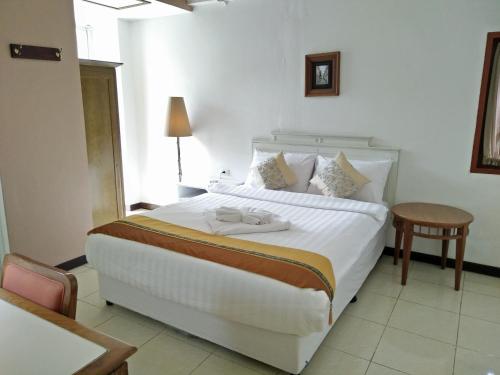曼谷JL Bangkok Hotel的卧室配有一张白色的大床和一张桌子