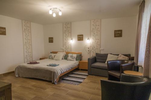 瑙吉伯尔热尼Szívem Csücske Vendégház的一间卧室配有一张床和一张沙发