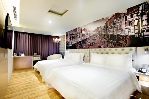 台南富驿时尚酒店的配有壁画的酒店客房内的两张床