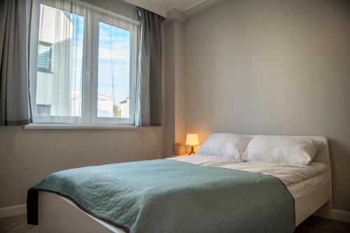 弗瓦迪斯瓦沃沃Apartamenty Jachtowa的卧室内的一张床位,带窗户