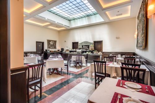 罗马戴克里泽诺酒店的一间带桌椅和天窗的用餐室