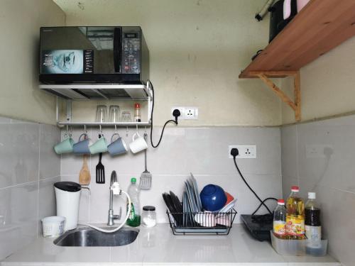 吉隆坡Cheras-Miharja Homestay @Sunway Velocity的厨房柜台设有水槽和微波炉