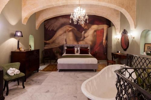 瓦莱塔The Coleridge Boutique Hotel In Valletta的卧室配有一张床,墙上挂有绘画作品