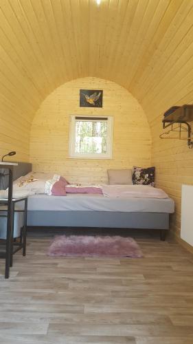 诺尔德霍尔茨Glamping Pod的黄色客房的一张大床,设有窗户
