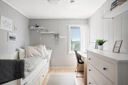 弗加尔巴卡Panoramablick - Meer - Familien - Remote Work的一间卧室配有一张床、一张书桌和一个窗户。
