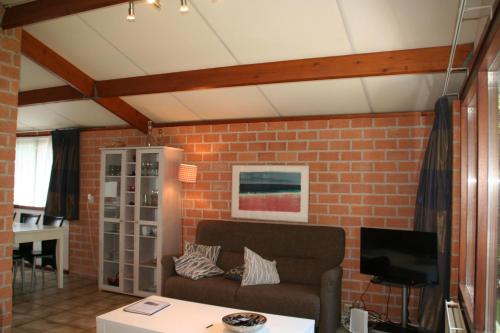 SchoorldamRekerlanden 173的带沙发和砖墙的客厅