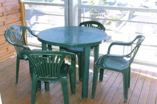 吕兹-圣索沃尔MS APPART** 5 PERS BALCON PISCINE LUZ 5MN的门廊上的一张绿色桌子和四把椅子