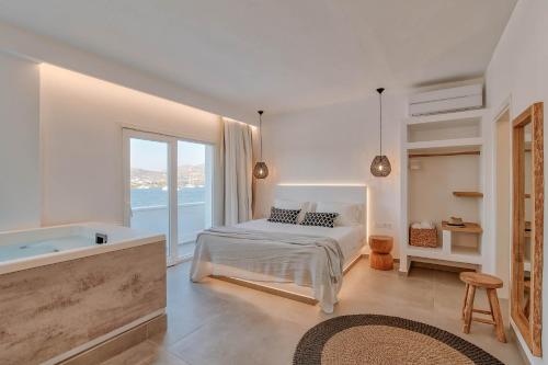 安迪帕罗斯岛Nautica Suites-Superior Seaview suite with jacuzzi的一间白色卧室,配有一张床和浴缸