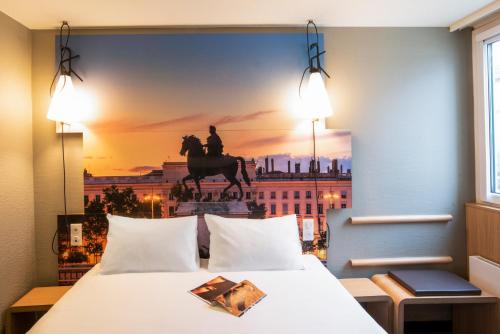 里昂宜必思里昂热尔兰梅里厄酒店的一间设有一张床铺的房间,上面有一张马雕像的照片