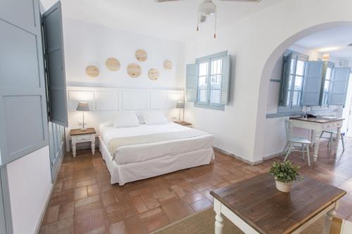塞维利亚圣克鲁兹套房公寓酒店的白色卧室配有床和桌子