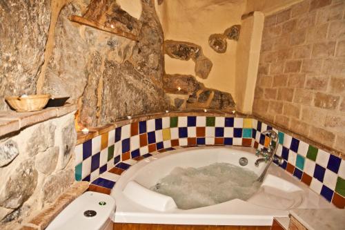 赫里卡La Casa Mora的带浴缸的浴室和石墙