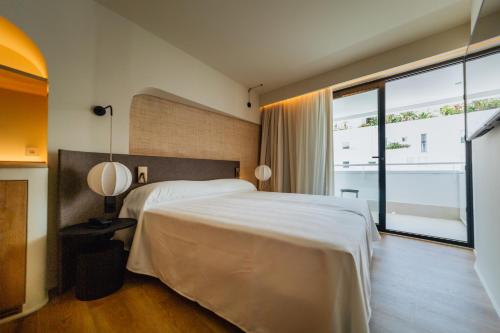 伊维萨镇El Hotel Pacha的一间卧室设有一张大床和一个大窗户