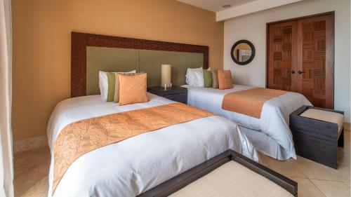 圣克鲁斯华特库Celeste Beach Residences Huatulco Curamoria Collection的酒店客房,设有两张床和镜子