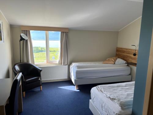 阿克雷里Hotel Natur Akureyri的酒店客房带两张床、椅子和窗户