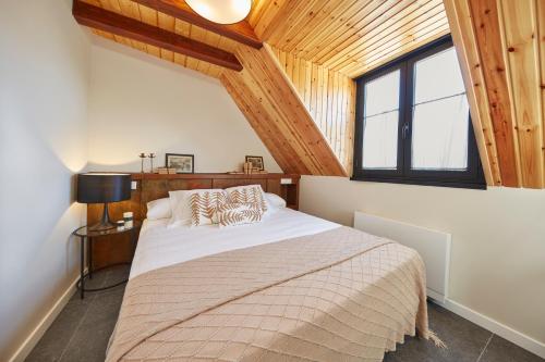 GistaínMirador de Chisten的一间带一张大床的卧室,位于一个拥有木制天花板的房间