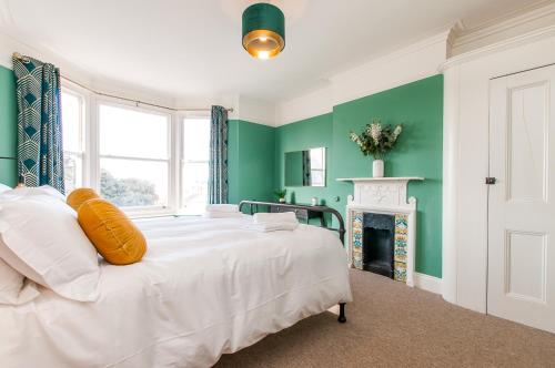 马盖特Queen Palm Apartment - Margate - 3 mins walk to beach的绿色的客房设有壁炉,配有一张白色的床。