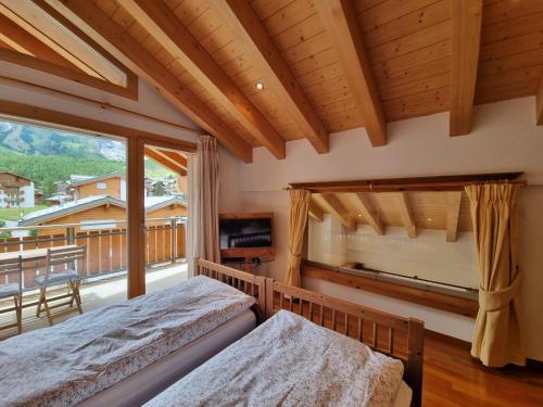 萨斯费佩拉度假屋的一间卧室设有两张床和大窗户