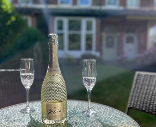 莱瑟姆-圣安妮34Three的一瓶香槟和一张桌子上的两杯酒