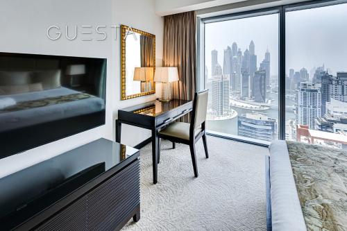 迪拜Marina Mall Apartments, Dubai Marina的配有一张床、一张书桌和一扇窗户的酒店客房