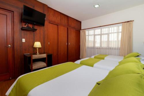 昆卡利迪策之家旅馆的一间卧室配有两张床和一台平面电视