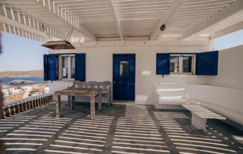MérikhasEternal Blue Kythnos的一个带蓝色门的门廊、一张桌子和长凳