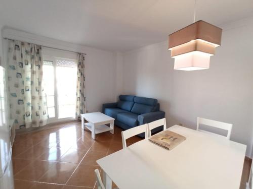 卡内拉岛Acogedor apartamento a 50 metros de la playa的客厅配有蓝色的沙发和桌子